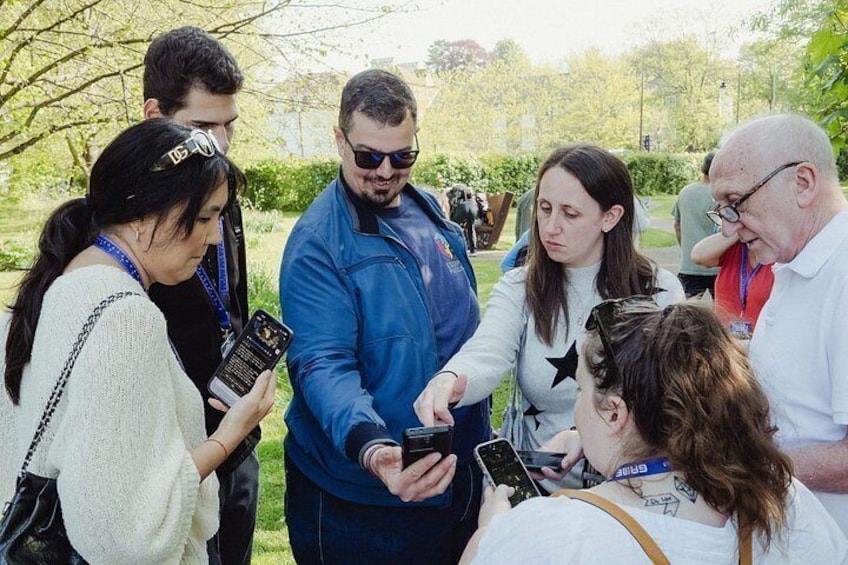 A group of people outdoors, some holding smartphones, possibly taking photos or videos. 4