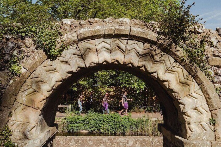 A stone archway with greenery and a pathway. 3