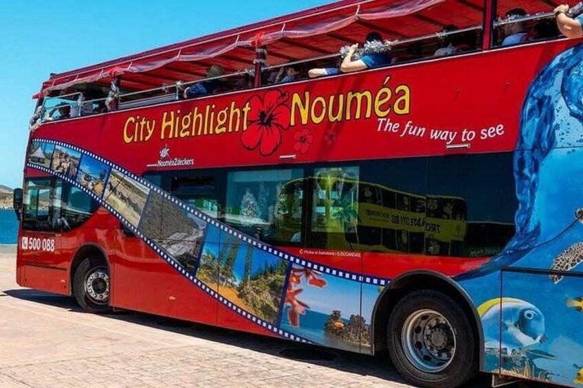 A red and blue bus with 'City Highlight Nouméa' and 'The fun way to see' written on it. 2