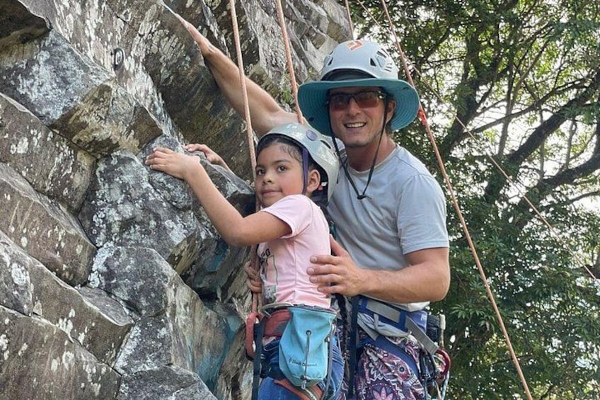 A person climbing a rocky wall with a child. 3