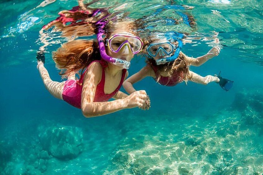 Two people snorkeling underwater in clear blue water. 1