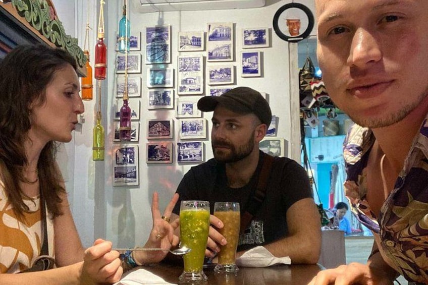 A group of people sitting at a table in a restaurant with various decorations and photographs on the wall. 5