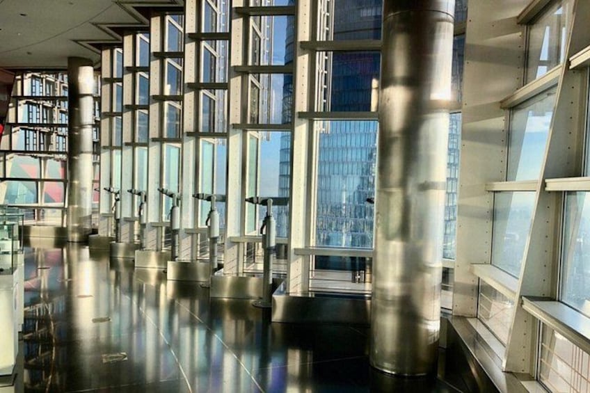 A modern building with reflective floors, large windows, and metallic columns. 4