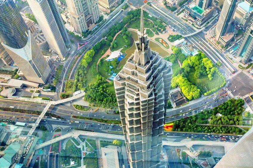 A cityscape with a prominent skyscraper, multiple roads, and green spaces. 3