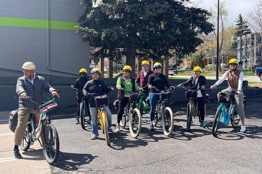 En gruppe mennesker på cykler med cykelhjelme står på en gade. 4