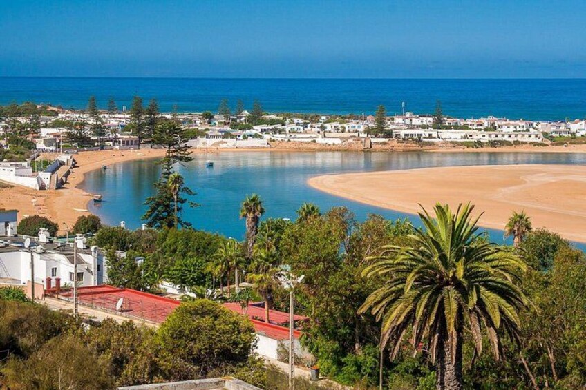 A coastal town with a beach, a bay, and a clear blue sky. 1