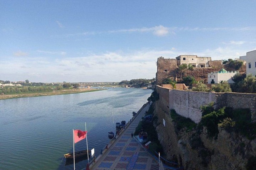 A river with a bridge, a castle-like structure, and a flag on a pier. 2