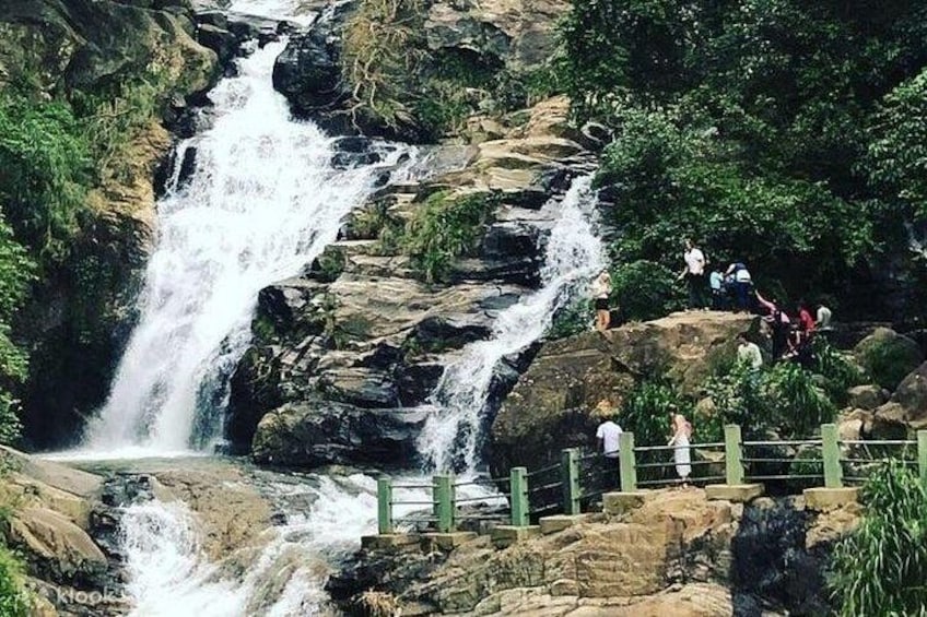 Una cascata che si getta su rocce, immersa nel verde lussureggiante. 3