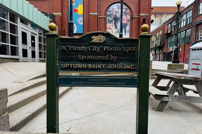 A signboard with text and a building in the background. 2