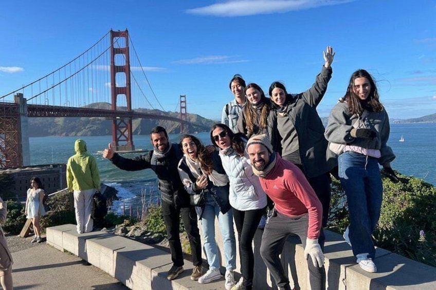 Een groep mensen staat op betonnen trappen, met de Golden Gate Bridge op de achtergrond. 5