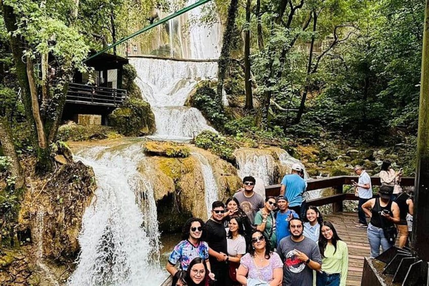 A waterfall, wooden walkways, and a group of people. 3