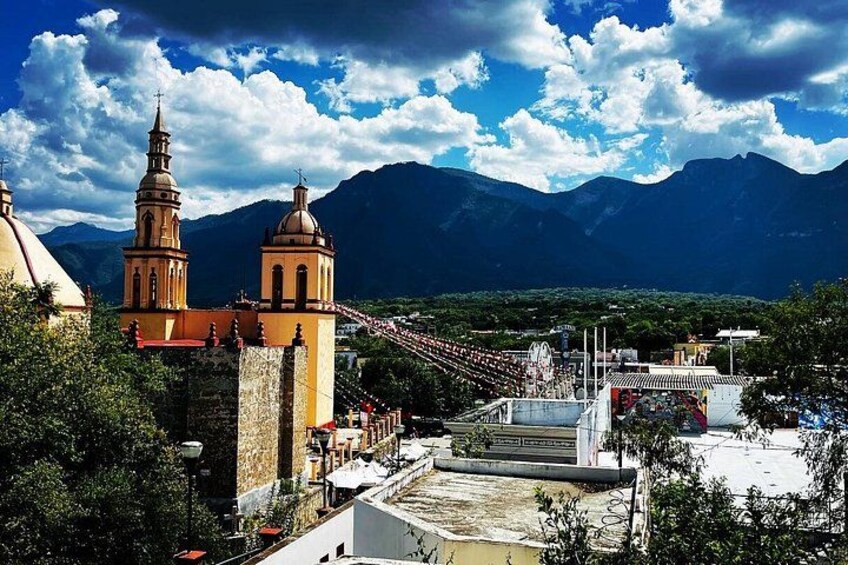 A church with two towers, a roller coaster, and mountains in the background. 5