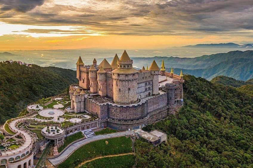 A castle on a hill with multiple towers, surrounded by lush greenery and a winding road. 4