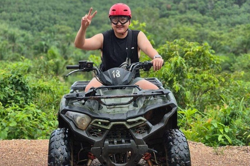 A person on an ATV in a green, vegetated area. 5