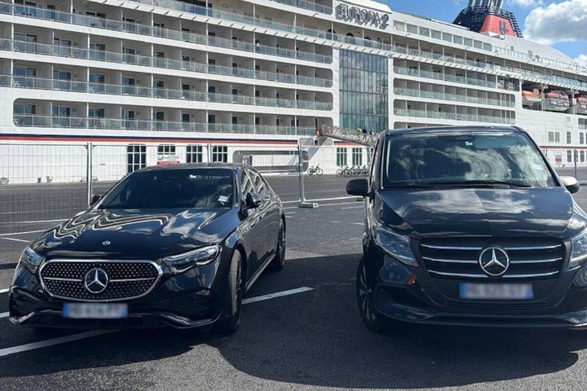 Deux voitures Mercedes-Benz noires étaient garées devant un grand terminal de croisière. 3