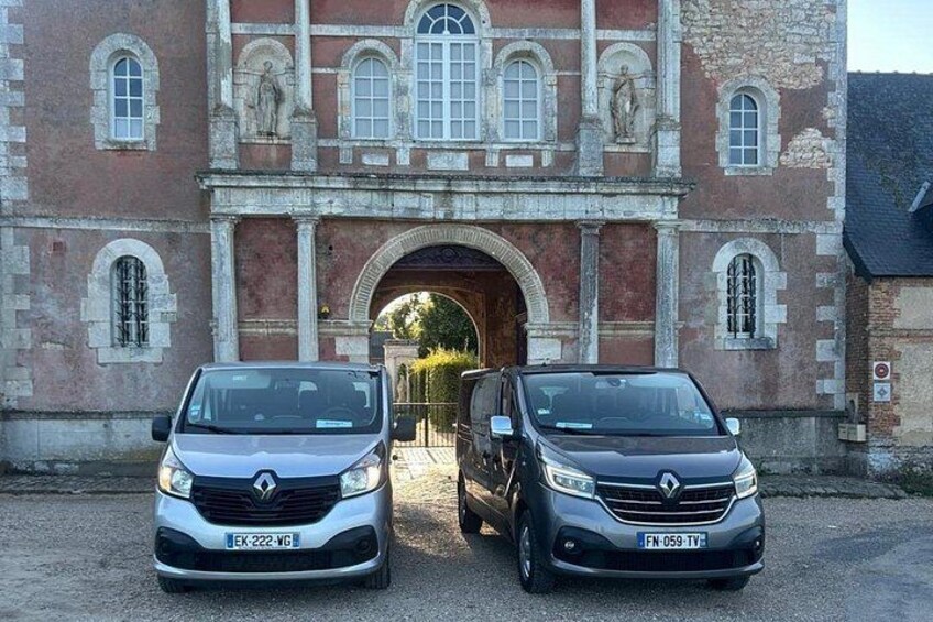 Deux voitures sont garées devant un bâtiment historique doté d’une entrée en arc de cercle. 2