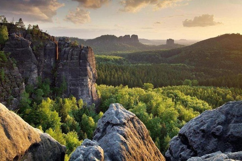 Paesaggio montuoso con affioramenti rocciosi e fitta foresta verde. 5