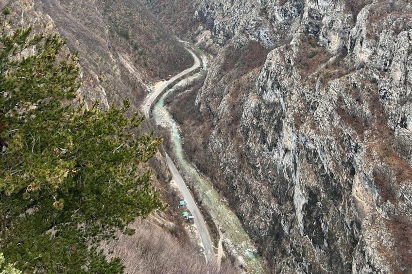 A winding road through a mountainous canyon with sparse vegetation and rocky terrain. 5