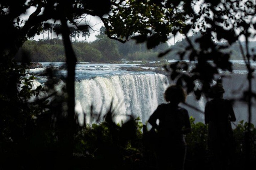A waterfall with people observing it. 4