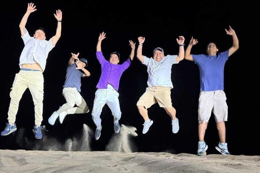 A group of people jumping in the air against a dark background. 5