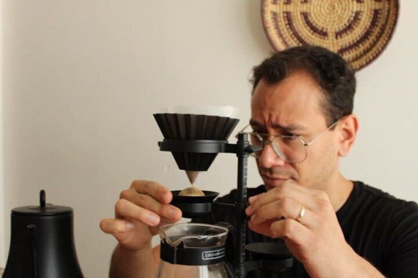Eine Person bedient eine Kaffeemühle. 4