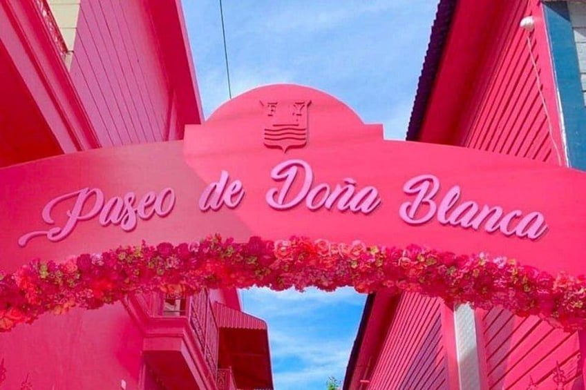 Un panneau rose sur lequel est inscrit « Paseo de Dona Blanca », entouré d’immeubles rouges. 4