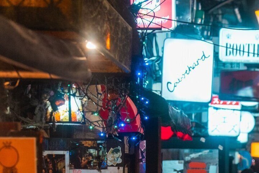 Ett stökigt inomhusutrymme med neonljusskyltar, inklusive en som visar texten ”Caivshard”. 5