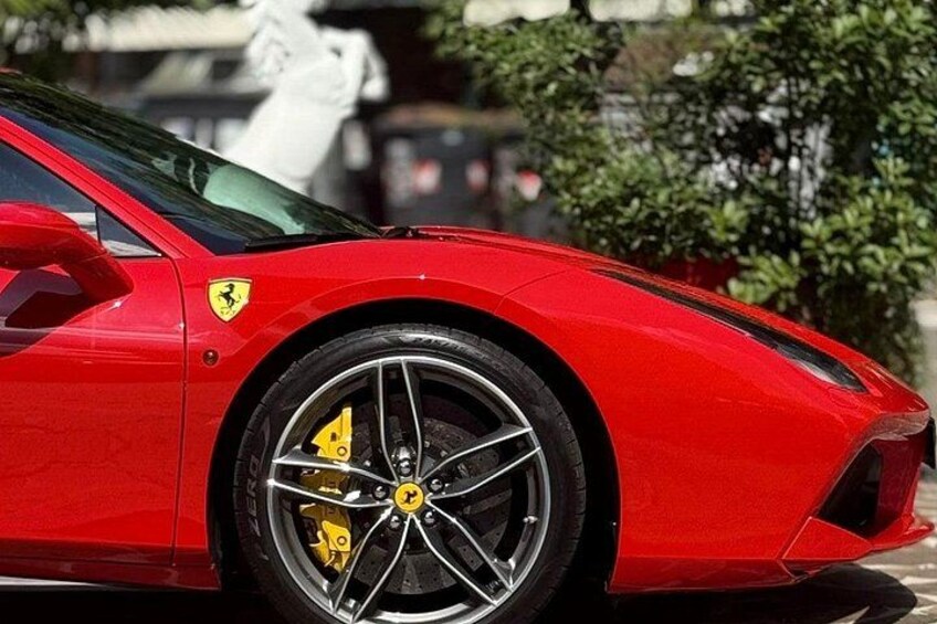 Een rode sportauto met gele remklauwen en een Ferrari-logo. 5