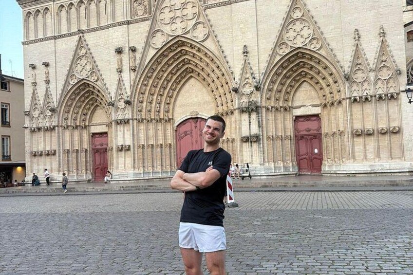 En mand står foran en stor katedral med detaljeret gotisk arkitektur. 3