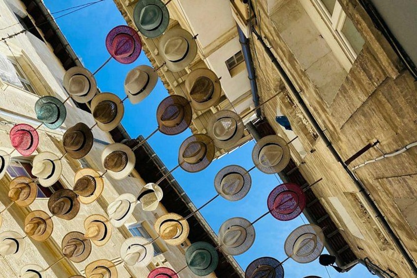 A collection of hats hanging on a building facade. 2