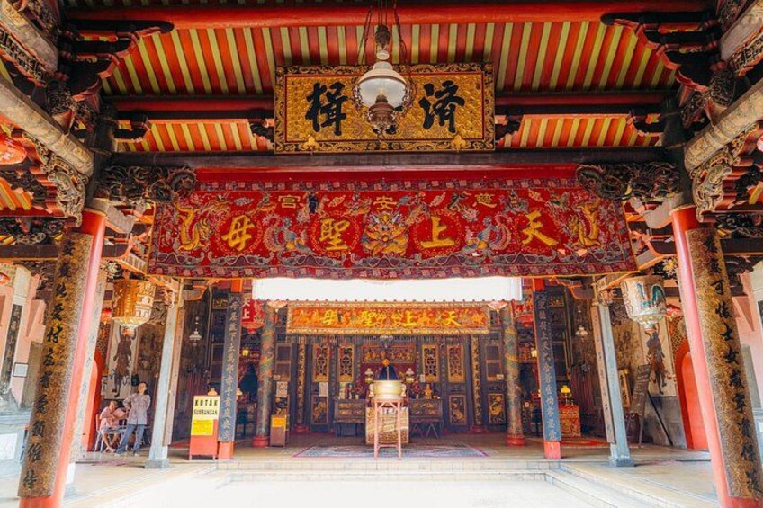 A traditional Chinese temple entrance with ornate decorations and a red banner. 1