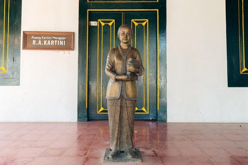 A statue of a man in traditional attire standing in front of a door with a sign reading 'R.A.KARTINI'. 2