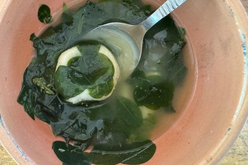 Un tazón de sopa con algas marinas y una cuchara. 5