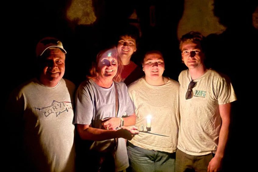A group of people standing together with a lit candle in the center. 2