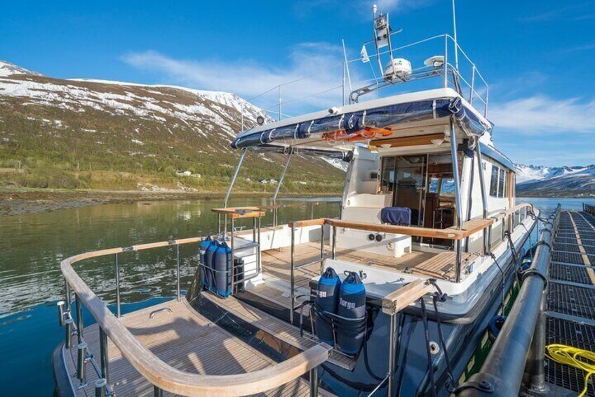 A boat docked at a pier with a mountainous landscape in the background. 3