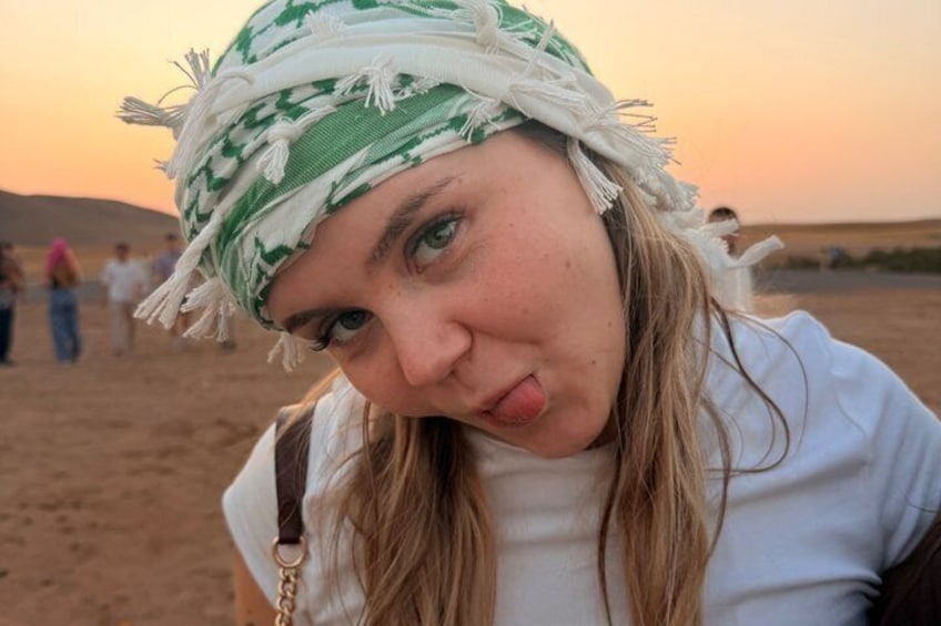 A person in a desert landscape with sand dunes in the background. 3