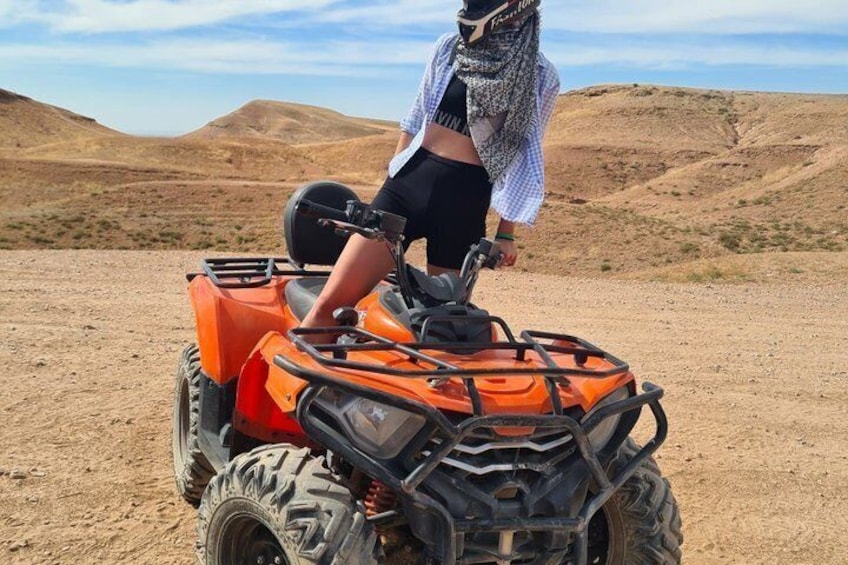 A person riding an orange ATV in a desert landscape. 5