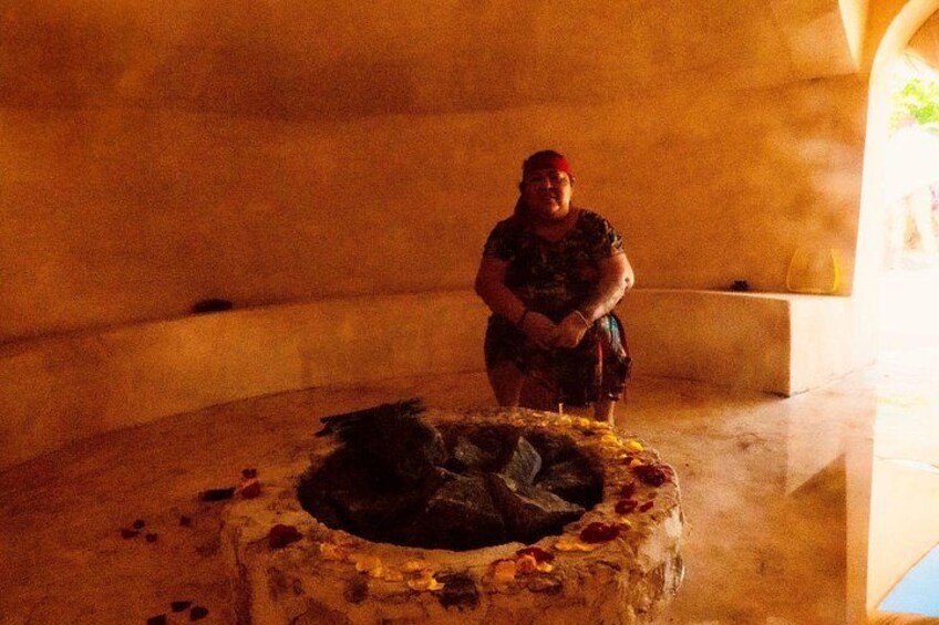 A person standing in a dimly lit room with a stone structure in the foreground. 2