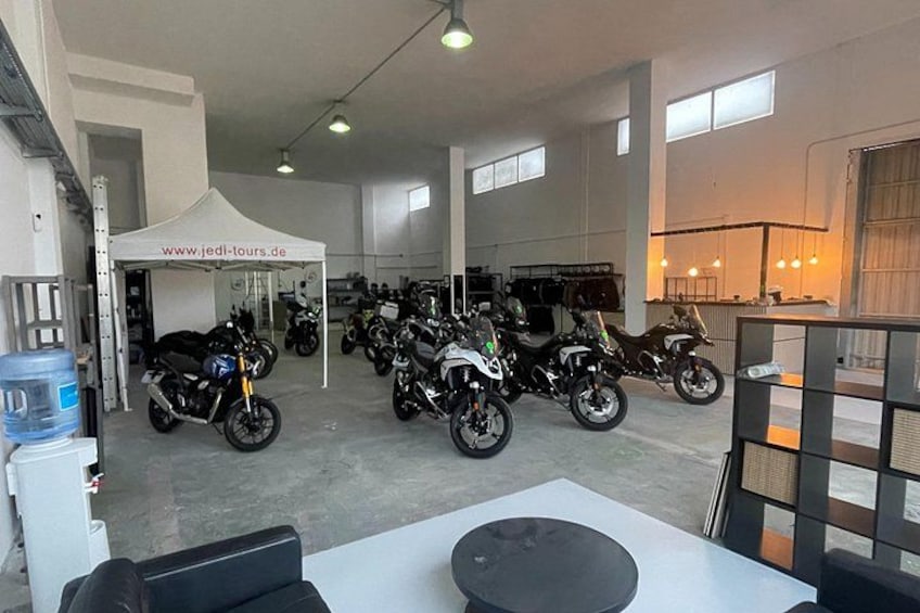 Un concessionnaire de motos où sont exposés plusieurs modèles, ainsi qu’une tente sur laquelle figure l’adresse d’un site web. 2