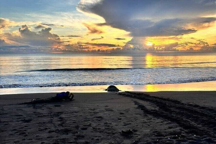 Une plage au coucher du soleil, avec une personne allongée sur le sable et un sac à dos à proximité. 1