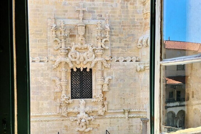 A detailed stone facade with ornate carvings and a small window. 2