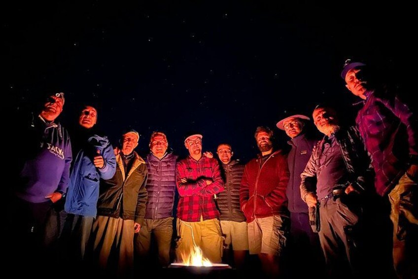 A group of people gathered around a campfire at night. 5