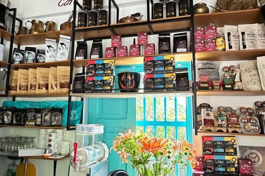 A coffee shop with shelves of coffee beans, bags of coffee, and a coffee machine. 5