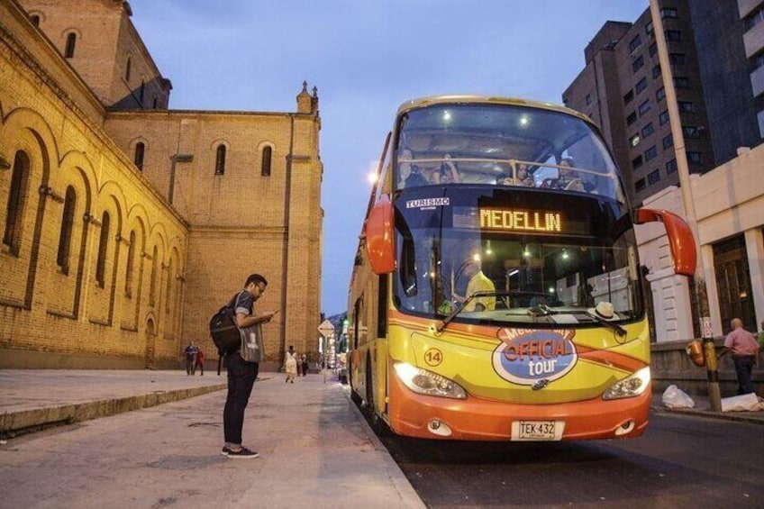 A yellow and orange bus labeled "Medellin" on a city street. 1