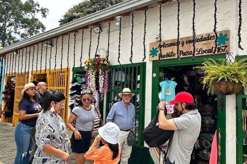 A group of people outside a store with a sign that reads "artesanías y variedades Pueblo Pasa Local 167". 4