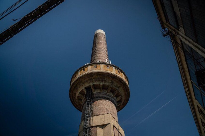 Una torre alta con una estructura cilíndrica y una base circular, rodeada de andamios de construcción. 2