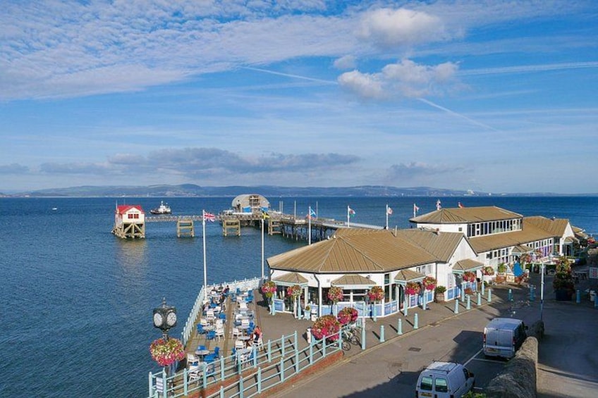 A coastal pier with buildings, a boat, and a clear sky. 2