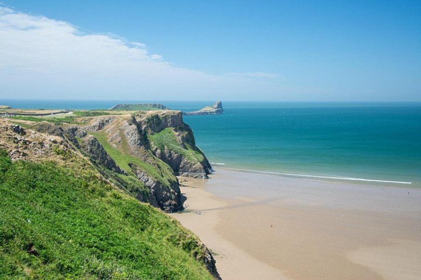 A coastal landscape with cliffs, a beach, and the ocean. 4