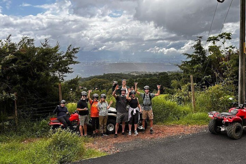 Un grupo de personas con cascos, un ATV rojo y una vista panorámica de la costa. 2
