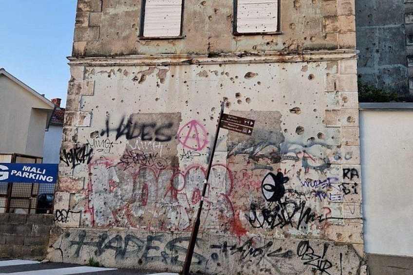 A building with graffiti and a sign for Mali Parking. 4